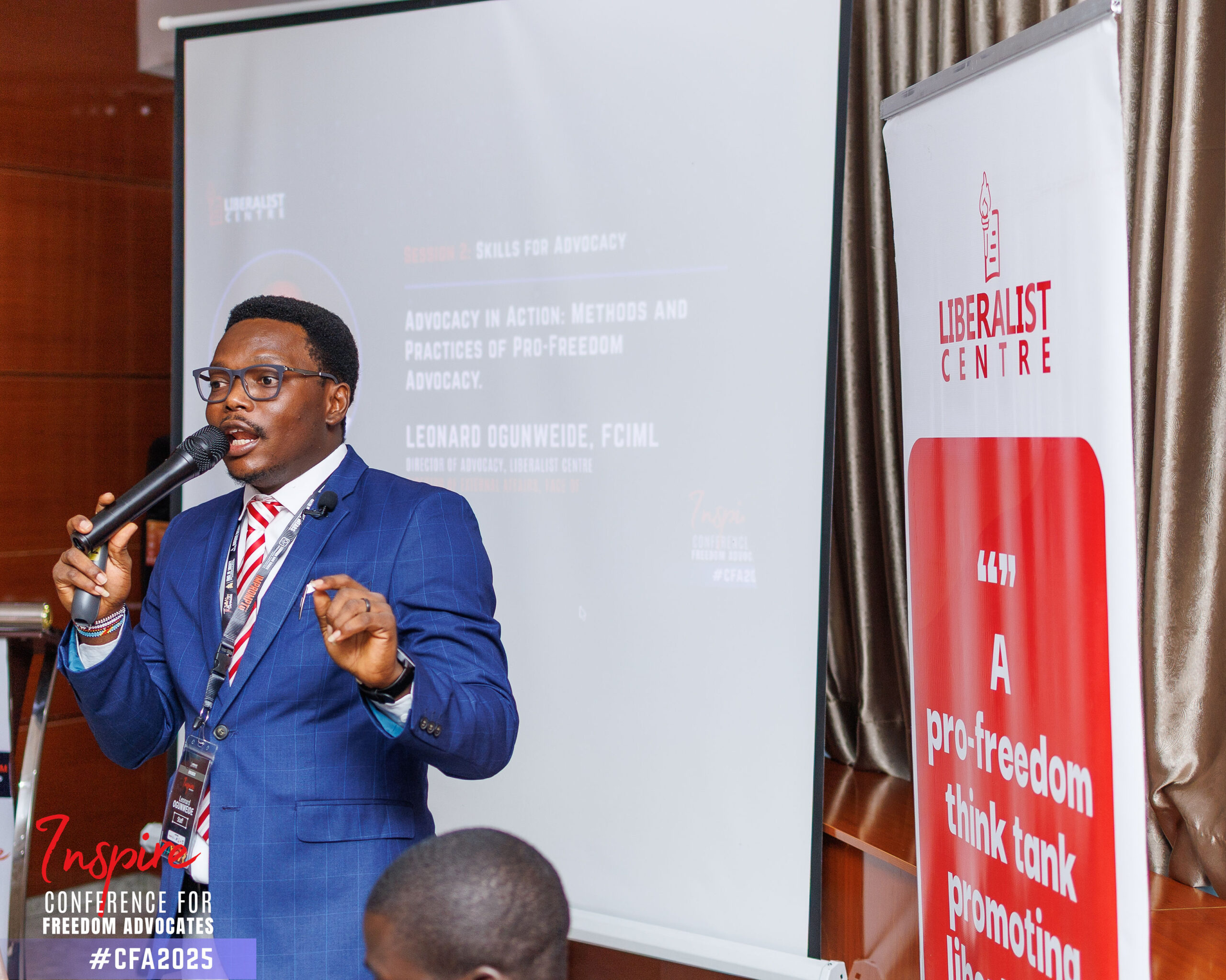 Leonard seated on a policy panel with other speakers